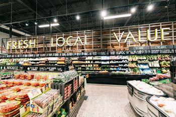 a supermarket aisle with a large sign that says fresh local value